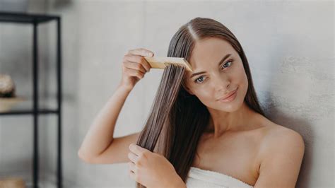 žena si rozčesáva dlhé zamotané vlasy