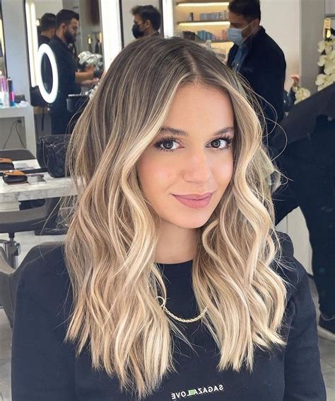 Žena s teplým tónom pleti a medovou blond ombré