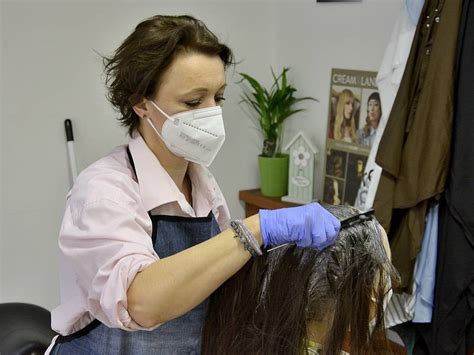 kaderník pracujúci s klientkou