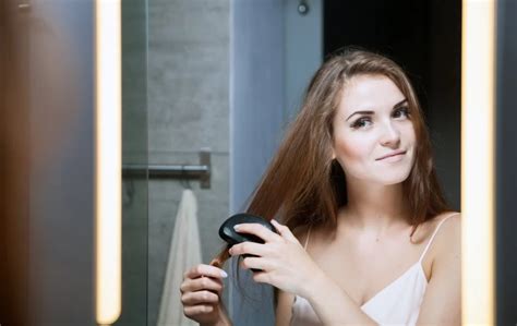 žena si rozčesáva hladké vlasy