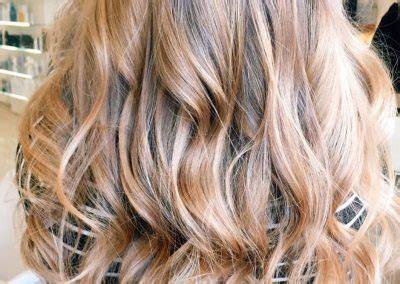 Kaderníčka aplikujúca balayage techniku na vlasy klientky
