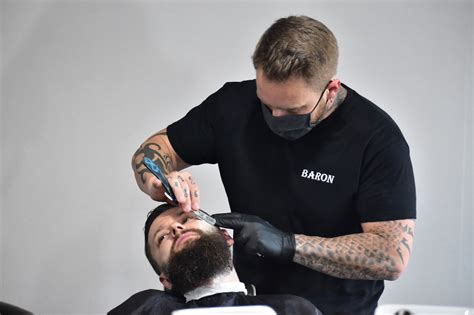profesionálny barber pri práci so zákazníkom