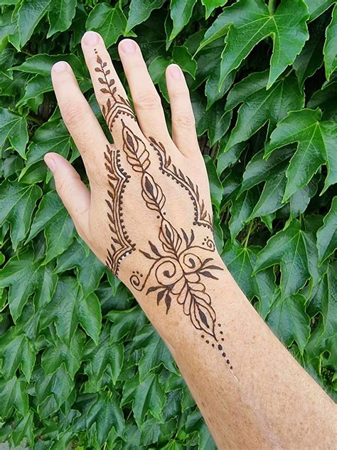 Detailný záber na jemný ornament nakreslený hennou na ruke