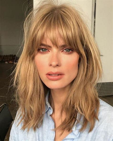 Margot Robbie s blond vlasmi a ofinou v štýle french bangs