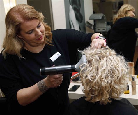 Kaderník strihajúci vlnité vlasy za sucha