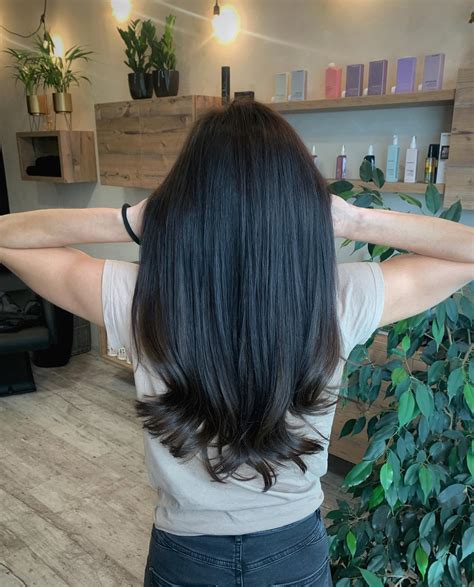 Žena v kaderníctve, ktorá si upravuje vlasy