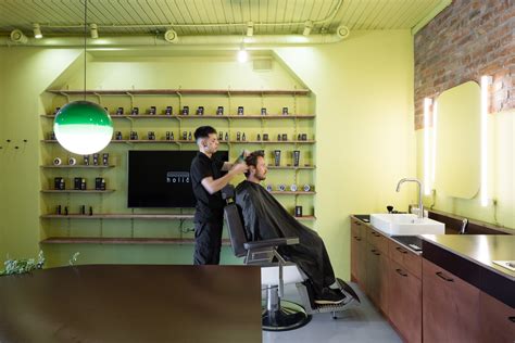 Interiér pánskeho holičstva HENA s kaderníkom pri práci