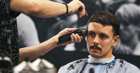 Muž v barber shope si necháva upravovať bradu