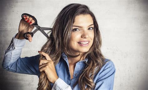 Žena pri kaderníckom kresle počas strihania vlasov