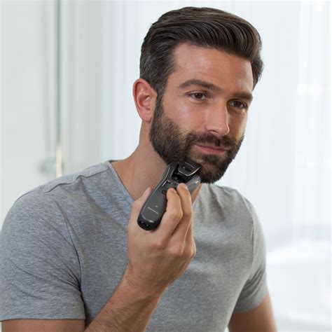 Zastrihávač fúzov a brady v ruke muža pri úprave