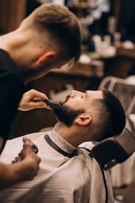 Detailná fotografia interiéru FLY Barber Studio s klientom v kresle a barberom pri práci